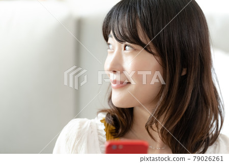 A woman watching a smartphone A woman watching a smartphone 79026261