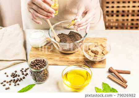 Woman mixing ingredients preparing coffee scrub for skin treatment 79026982