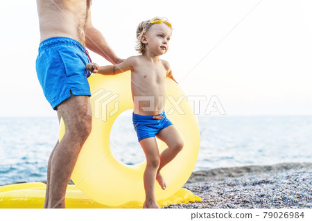 Father with his son enjoying their summer vacation by the ocean. Childhood lifestyle , holiday travel, beach scene concept 79026984