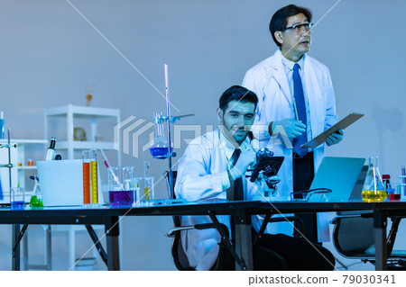 Team of research scientists analysing test trial new generation vaccine data. 79030341