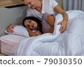 Couple lying comfortable sheets bed at night 79030350