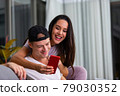 Happy couple enjoying media content in a smart phone 79030352