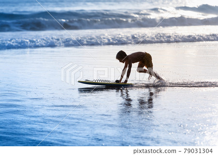 Boy with bodyboard have fun on sea beach Boy with bodyboard have fun on sea beach 79031304