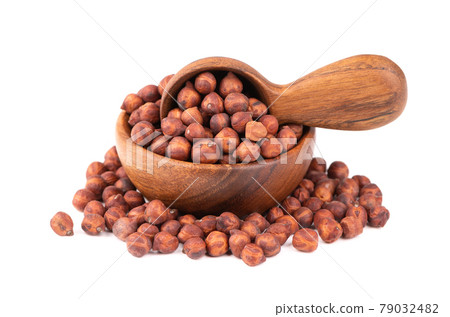 Pile of brown chickpeas in wooden bowl and spoon, isolated on white background. Brown chickpea. Garbanzo, bengal gram or chick pea bean. 79032482