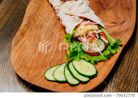 pita with vegetables and chopped cucumbers. vegetarian roll. pita with vegetables and chopped cucumbers. vegetarian roll. 79032770