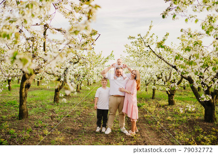 family with son and daughter in spring flowering garden. cleft lip in infants. family with son and daughter in spring flowering garden. cleft lip in infants. 79032772