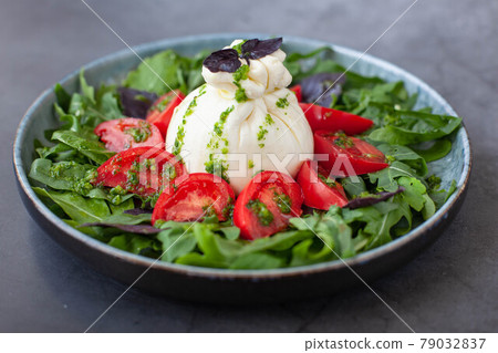 Salad with traditional italian burrata cheese with tomatos, basil and arugula 79032837