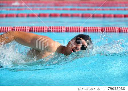 Swimmer man athlete swimming in pool lanes doing a crawl lap. Swim race freestyle 79032988