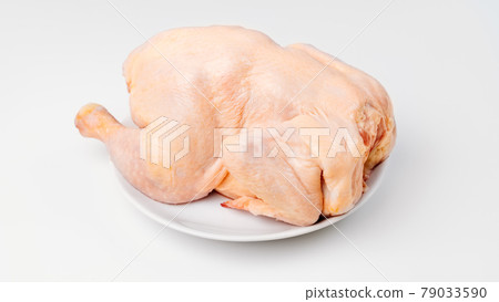 carcass of raw chicken on a white plate on a white background. carcass of raw chicken on a white plate on a white background. 79033590