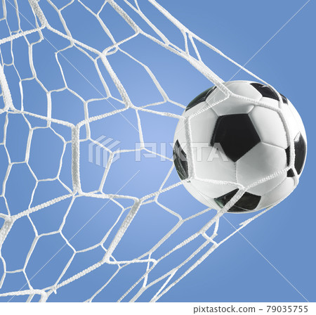 Goal of a soccer ball in the goal net on a blue background 79035755