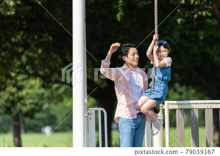 Young parents and children playing in the park 79039167