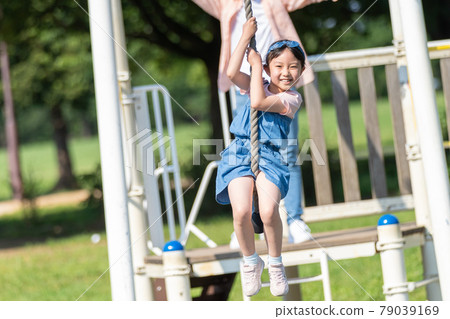 Young parents and children playing in the park 79039169