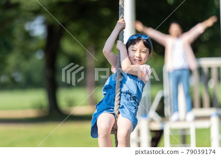 Young parents and children playing in the park 79039174