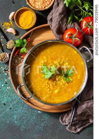 Indian cuisine. Traditional Indian spicy lentil puree soup with herbs on a dark background. Top view flat lay background. Copy space. 79039946
