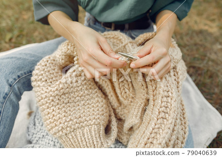 Girl sitting in a summer park and knitting 79040639