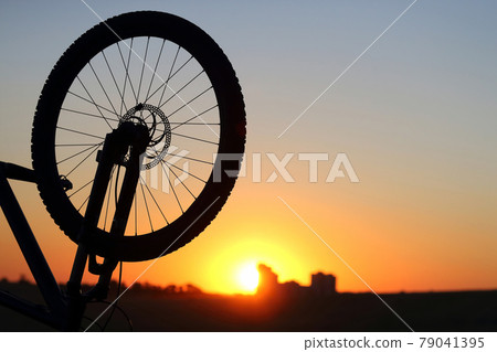 silhouette of a Bicycle wheel at sunset. silhouette of a Bicycle wheel at sunset. 79041395