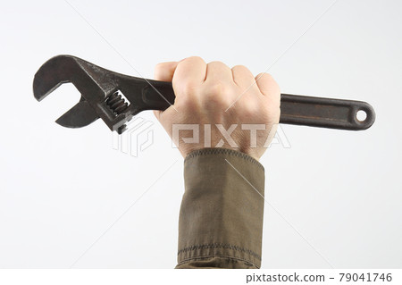 hand of a man with a wrench on a light background 79041746