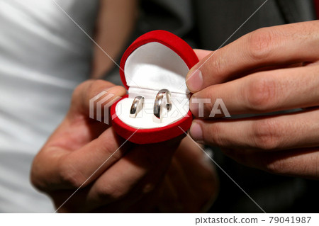 groom holds a box with gold wedding rings close up 79041987