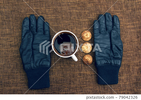 leather gloves next to a hot cup of coffee leather gloves next to a hot cup of coffee 79042326