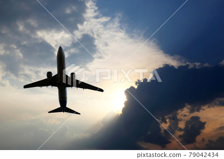 passenger plane flies in juicy clouds to meet the sun 79042434