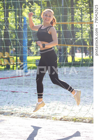 cute young sporty girl in jump running at a distance 79042625