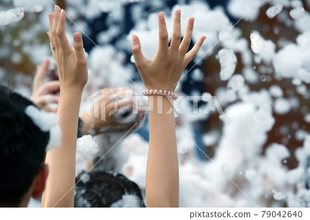 raised hands of a woman in a foam disco raised hands of a woman in a foam disco 79042640