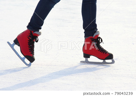 feet in red skates on an ice rink 79043239