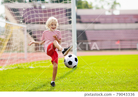 Kids play football. Child at soccer field. Kids play football. Child at soccer field. 79043336
