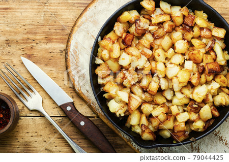 Baked fried potatoes in iron skillet 79044425
