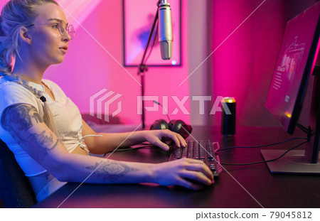 Focused Beautiful Blonde Gamer Girl Playing Online Video Game on Her Personal Computer. Focused Beautiful Blonde Gamer Girl Playing Online Video Game on Her Personal Computer. 79045812