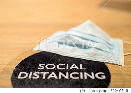 Social distancing text and face mask on table at restaurant 79046546