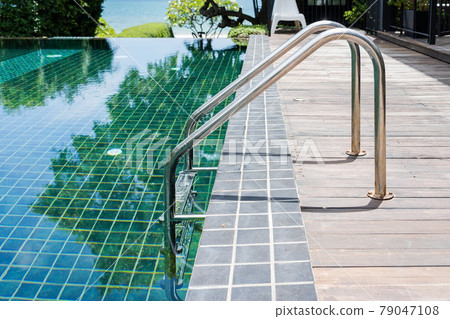 Grab bars ladder in the blue swimming pool 79047108