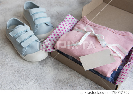 Clothes fir kids in an open cardboard box 79047702