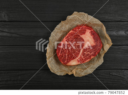 Close up raw beef ribeye steak on paper 79047852