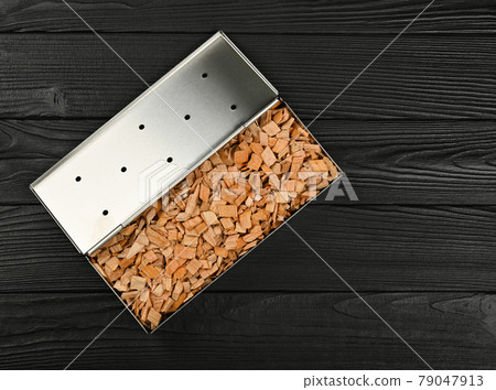 Metal smoker box with wood chips on table Metal smoker box with wood chips on table 79047913