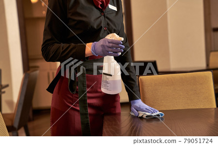 Person with cleaning detergent washing a table Person with cleaning detergent washing a table 79051724