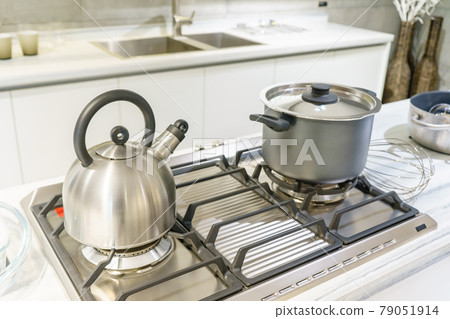 Close-up of stainless steel cooking pot and kettle boiling on gas stove in contemporary modern home kitchen. Selective focus on pot. 79051914