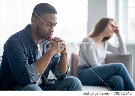 Family Problems. Portrait Of Upset Interracial Couple Sitting On Couch After Quarrel Family Problems. Portrait Of Upset Interracial Couple Sitting On Couch After Quarrel 79052143