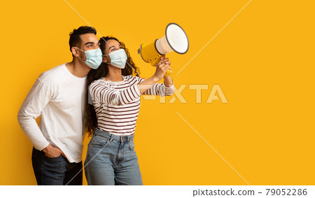 Middle Eastern Couple In Medical Masks Making Announcement With Loudspeaker 79052286
