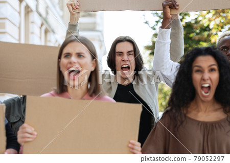 Closeup of furious multiracial protestors with empty placards Closeup of furious multiracial protestors with empty placards 79052297