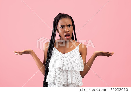 Irritated African American woman showing I DON'T KNOW gesture, shrugging shoulders on pink studio background Irritated African American woman showing I DON'T KNOW gesture, shrugging shoulders on pink studio background 79052610