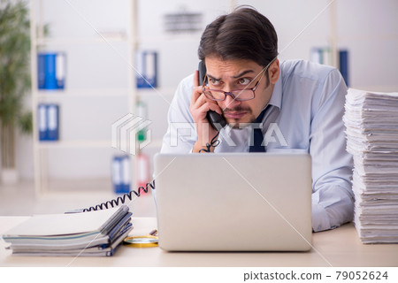 Young businessman employee unhappy with excessive work in the of Young businessman employee unhappy with excessive work in the of 79052624