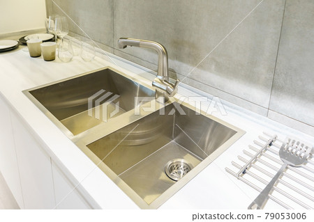 Stainless kitchen sink and Tap water in the kitchen. The interior of the kitchen room of the apartment. Built-In Appliances. Kitchen Appliance. Domestic Appliances 79053006