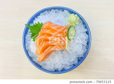 Salmon sashimi on ice serve with fresh wasabi and carrot slide, Japanese food style. Top view with copy space and text Salmon sashimi on ice serve with fresh wasabi and carrot slide, Japanese food style. Top view with copy space and text 79053125