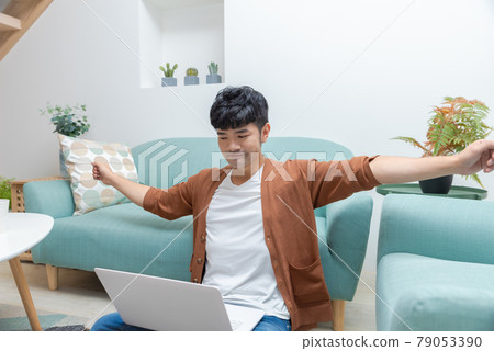 Young man working on computer at home Young man working on computer at home 79053390