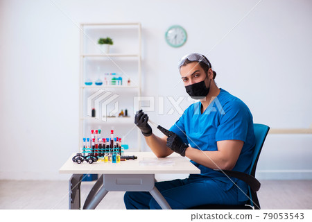 Young male biochemist testing blood samples in pandemic concept Young male biochemist testing blood samples in pandemic concept 79053543