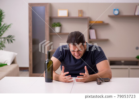 Young male alcoholic committing suicide at home Young male alcoholic committing suicide at home 79053723