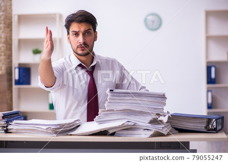 Young businessman employee unhappy with excessive work in the office 79055247