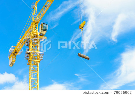 Construction site. Construction cranes and high-rise building under construction against blue sky. Construction site. Construction cranes and high-rise building under construction against blue sky. 79056962