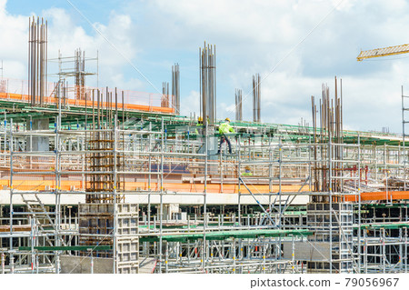 Modern building is under construction, metal scaffolding and blue sky Modern building is under construction, metal scaffolding and blue sky 79056967